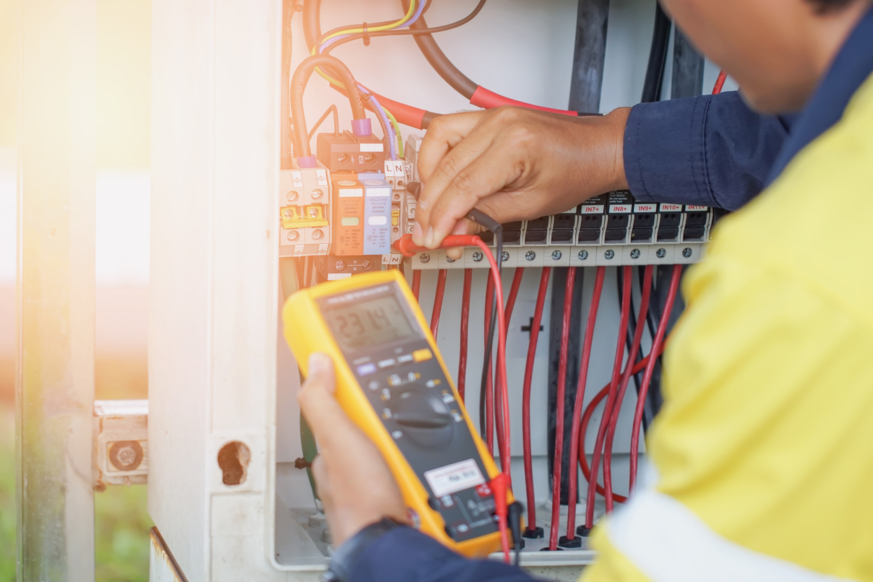 Workers use a Multimeter to measure the voltage of electrical wires produced from solar energy to confirm systems working normally